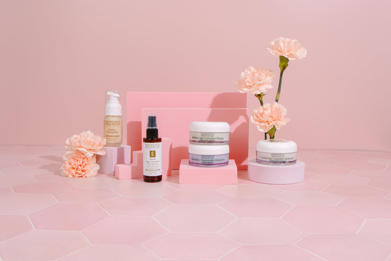 various Eminence Organics product with a pink background and flowers 