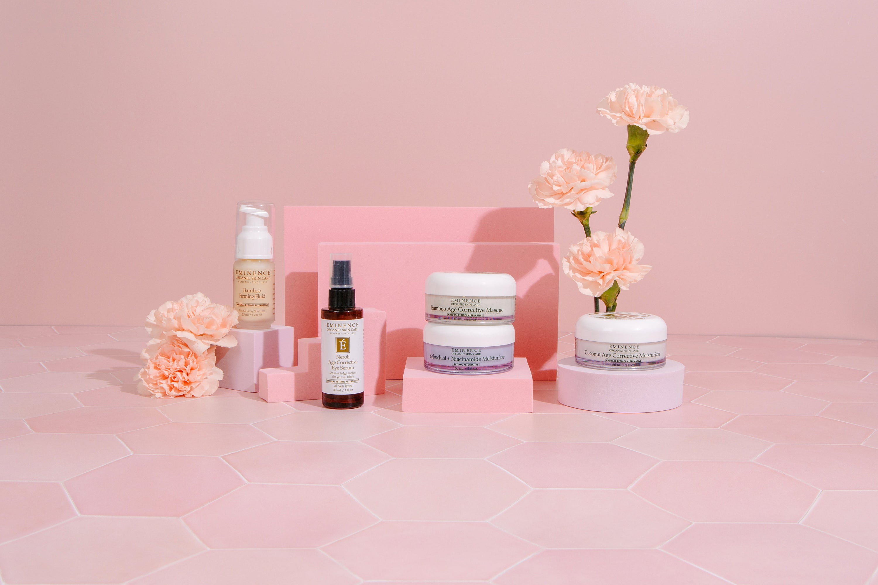 various Eminence Organics product with a pink background and flowers 